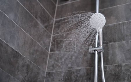 Wassertropfen, die aus dem Duschkopf in Badezimmernähe fließen. Verkauf von Badezimmerarmaturen Konzept