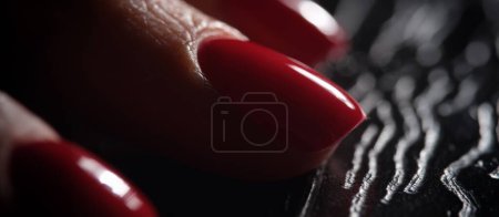 Téléchargez les photos : Stylish beautiful red nails on dark background. Classic graceful manicure concept - en image libre de droit