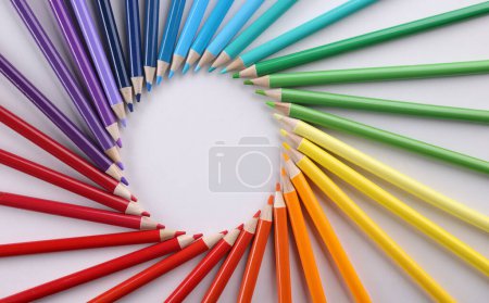 Colored pencils in acircle closeup. Colored pencils lie around on white background. Pencil drawing concept