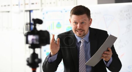 Téléchargez les photos : Blogueur homme d'affaires entraîneur en ligne criant concept de caméra d'intro - en image libre de droit