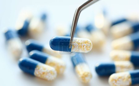 Téléchargez les photos : Pharmacien tenant pinces pilule gros plan concept de fond médical - en image libre de droit