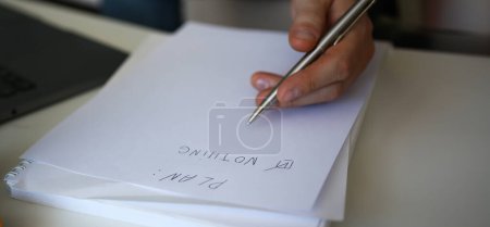 Male hand hold silver pen composing to do list for life closeup