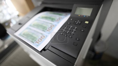 Papierbogen auf einem Drucker mit gefälschtem Dollarschein-Hintergrund