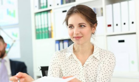 Portrait of attractive brunette smiling and looking away in classy white bluse. Pretty female working important business project that can determine future of colossal company. Company meeting concept