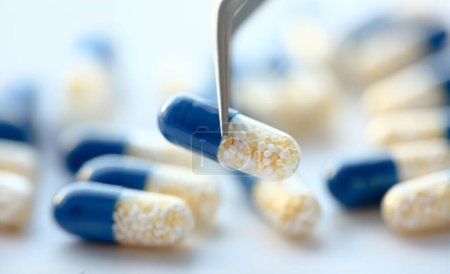 Pharmacien tenant pinces pilule gros plan concept de fond médical
