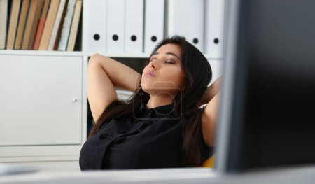mujer china bastante joven en la oficina sentarse a la mesa terminar todo el trabajo tiene un descanso puede permitirse relajarse disfrutar de su concepto de trabajo
