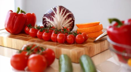 Photo for Assorted Raw Healthy Vegetable Food Photography. Red Tomatoes, Cabbage and Orange Fruit on Wooden Cutting Board. Vegan and Diet Ingredients in Kitchen. Healthy Lifestyle Culinary and Fresh Vitamins - Royalty Free Image