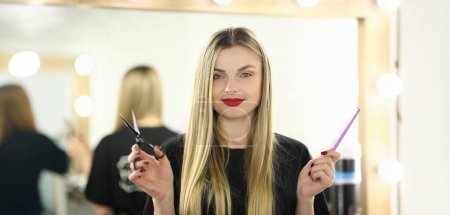Photo for Hairdresser Woman Holding Scissors and Hairbrush. Blonde Hairstylist with Tool for Hair. Female Beautician with Comb for Hairdo Standing in Beauty Salon. Haircut Stylist Looking at Camera Shot - Royalty Free Image