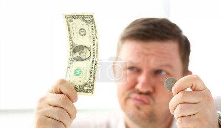 Photo for Arms of thoughtful man holding paper and coin currency trying to invent some good solution closeup - Royalty Free Image