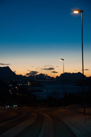 Téléchargez les photos : Un seul lampadaire illumine une route du centre de la Norvège au début de la soirée des longs hivers norvégiens. - en image libre de droit