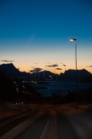 Téléchargez les photos : Un seul lampadaire illumine une route du centre de la Norvège au début de la soirée des longs hivers norvégiens. - en image libre de droit