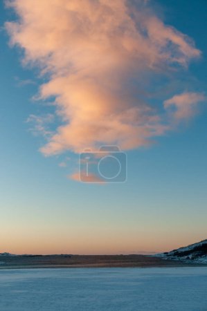 Foto de Una nube roja iluminada por un sol bajo en invierno en la vía ártica. - Imagen libre de derechos