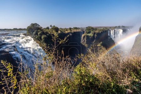 Foto de Foto exterior de un arco iris frente a Victoria Falls, Zimbabue, en una tarde. - Imagen libre de derechos