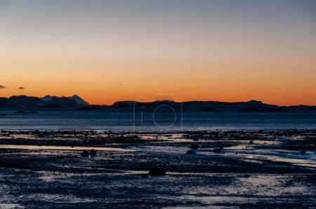 Foto de Un resplandor naranja de la extensa hora dorada en el ártico norte de Noruega, durante el invierno. - Imagen libre de derechos