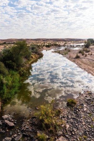 Téléchargez les photos : Des nuages faiblement dispersés se reflètent dans la rivière Fish, dans le sud de la Namibie - en image libre de droit