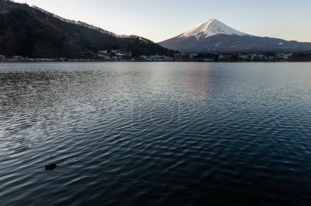 Photo for Mount Fuji on a bright winter morning, as seen from across lake Kawaguchi, and the nearby town of Kawaguchiko. - Royalty Free Image