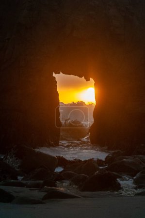Foto de Detail of the Keyhole arch at Pfeiffer beach, with the setting sun to be just behind it. - Imagen libre de derechos