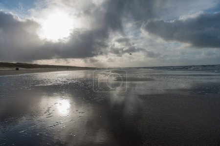 Téléchargez les photos : Nuages se reflétant dans un résidu d'eau sur la plage près d'Egmond aan Zeen en Hollande-Septentrionale, Pays-Bas. - en image libre de droit
