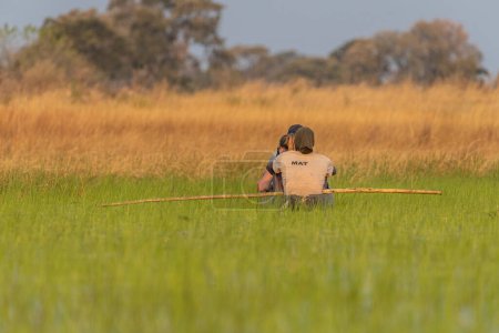 Foto de Delta del Okavango, Botsuana - 3 de agosto de 2022. Un grupo de turistas siendo guiados por guías locales a lo largo del delta del okavango, mientras buscan vida silvestre - Imagen libre de derechos