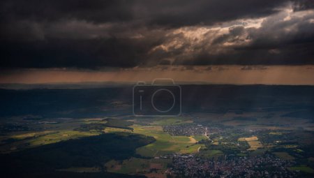Téléchargez les photos : Rayons de soleil capturés par des averses de pluie éparses au-dessus du centre de l'Allemagne, vu des airs, juste avant le coucher du soleil
. - en image libre de droit