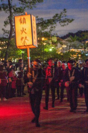 Photo for Miyajima, Japan - December 31, 2019. Participants of the Chinkasai Fire Festival at Itsukushima Shrine, near Hiroshima, carry large burning torches around the sea shore as part of a ritual to - Royalty Free Image