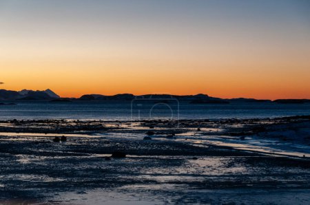 Ein orangefarbener Schein der ausgedehnten goldenen Stunde im arktischen Nordnorwegen, im Winter.
