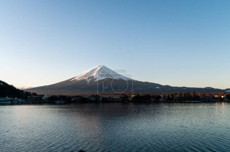 Photo for Mount Fuji on a bright winter morning, as seen from across lake Kawaguchi, and the nearby town of Kawaguchiko. - Royalty Free Image