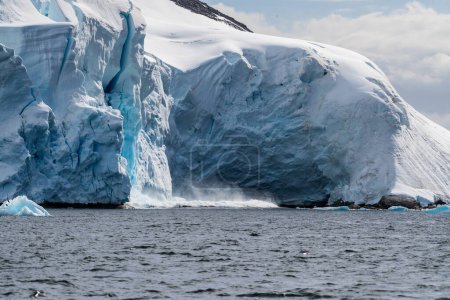 Teleaufnahme eines riesigen Eisbrockens, der von einer Eisdecke abkalbt. Graham Passage in der Nähe der Charlotte Bay auf der antarktischen Halbinsel