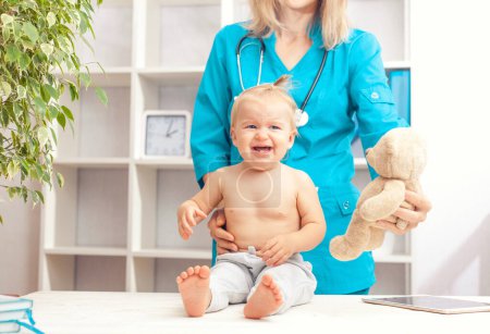 Téléchargez les photos : Pédiatre Docteur examinant le petit bébé à la clinique. Concept de santé bébé - en image libre de droit