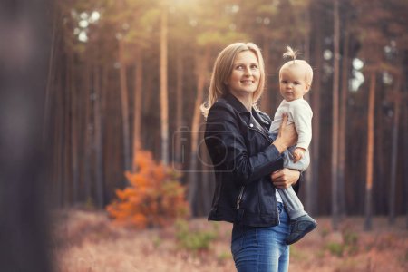 Téléchargez les photos : Mère et petite fille marchent dans une forêt de conifères - en image libre de droit