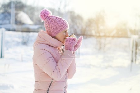 Foto de Hermosa mujer feliz sonriente de invierno con taza al aire libre. riéndose chica al aire libre con caliente bebida - Imagen libre de derechos