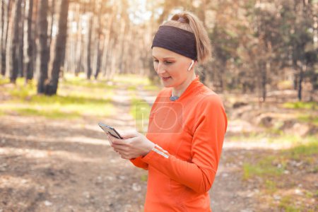 Photo for Young girl on a morning run in a sunny pine forest. cardio workout and healthy lifestyle - Royalty Free Image