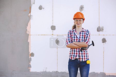 Photo for Insulation of the house with polyfoam. The female worker stands in front of a wall insulated with foam plastic - Royalty Free Image