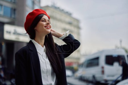 Foto de Una mujer sonriente con dientes de negocios camina en la ciudad contra el telón de fondo de los edificios de oficinas, ropa elegante y maquillaje, paseo de primavera, viajes. Foto de alta calidad - Imagen libre de derechos