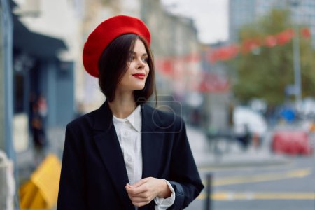 Foto de Mujer de moda sonrisa primavera caminando en la ciudad en ropa elegante con labios rojos y boina roja, viajes, color cinematográfico, estilo vintage retro, estilo de vida de moda urbana. Foto de alta calidad - Imagen libre de derechos