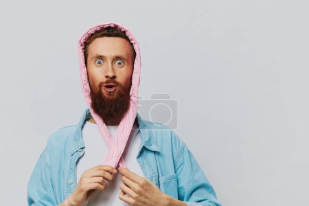 Téléchargez les photos : Homme drôle dans un portrait de chapeau rose sur un fond gris clair. Sourire et émotions positives. Photo de haute qualité - en image libre de droit