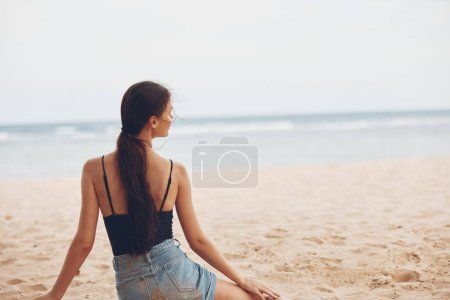 Foto de Mujer naturaleza natural sonrisa océano libertad pelo atractivo vacaciones caucásicas vacaciones hermosa arena al aire libre modelo sentado playa mar solo viaje relajarse - Imagen libre de derechos