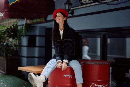 Foto de Mujer sentada fuera de una cafetería y bar en una calle de la ciudad, elegante imagen de moda de la ropa, vacaciones y viajes, paseo por la ciudad. Foto de alta calidad - Imagen libre de derechos