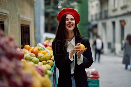 Photo for Woman smile with teeth tourist walks in the city market with fruits and vegetables choose goods, stylish fashionable clothes and makeup, spring walk, travel. High quality photo - Royalty Free Image