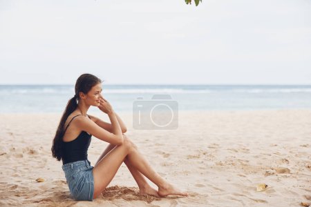 Foto de Arena mujer vacaciones costa viaje sentado bastante solo atractivo blanco playa al aire libre sonrisa sexy adulto libertad despreocupado vacaciones mar relajarse naturaleza - Imagen libre de derechos