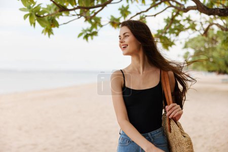 Foto de Caminar mujer cielo pelo largo sonrisa naturaleza feliz bolsa océano orilla agua tropical hermosa arena vacaciones estilo de vida joven mar verano playa sol - Imagen libre de derechos