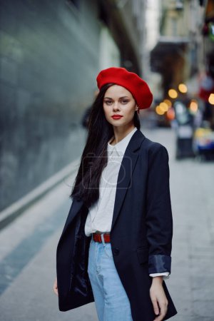 Foto de Retrato de mujer de moda caminando turista en ropa elegante con labios rojos caminando por la calle estrecha de la ciudad, viajes, color cinematográfico, estilo vintage retro, dramático. Foto de alta calidad - Imagen libre de derechos