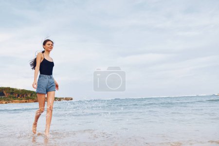Téléchargez les photos : Femme copier bikini beauté vague plage coucher de soleil loisirs espace soleil sourire joyeux course bronzage cheveux détendre été marche style de vie jeune mer long voyage - en image libre de droit