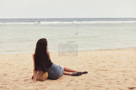 Téléchargez les photos : Voyage femme bali cheveux seul eau vacances plage tropical femelle sable sourire mer heureux assis mode nature personne liberté style de vie attrayant - en image libre de droit