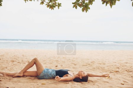 Foto de Mujer arena sol viaje bali naturaleza vacaciones solo vacaciones caucásico sentado playa sonrisa mujer espalda natural libertad vista mar moda al aire libre bronceado - Imagen libre de derechos