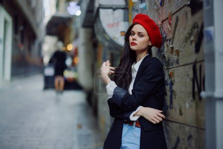 Photo for Fashion woman portrait walking tourist in stylish clothes with red lips walking down narrow city street, travel, cinematic color, retro vintage style, dramatic. High quality photo - Royalty Free Image