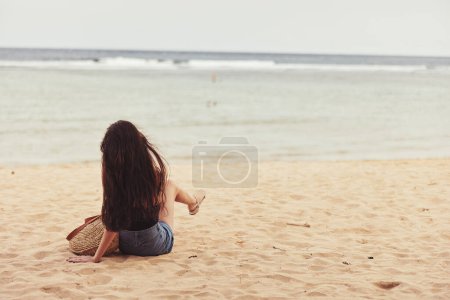 Foto de Despreocupado mujer verano sentado espalda costa cuerpo sonrisa vista viaje arena playa tropical mar caucásico vacaciones naturaleza vacaciones libertad natural bali chica - Imagen libre de derechos