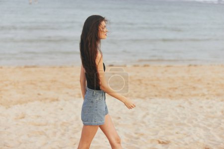 Foto de Mujer joven vacaciones pacífico jean océano al aire libre adulto pelo libre atardecer estilo de vida sonrisa corriendo mar playa arena verano largo naturaleza vacaciones belleza - Imagen libre de derechos