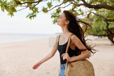 Téléchargez les photos : Femme sable ciel sac mer Voyage caucasien rivage nature vacances tropical libre plaisir plage jeune soleil sourire soleil été océan - en image libre de droit