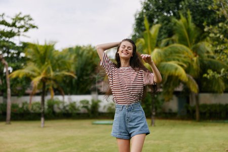 Foto de Mujer parque camiseta sombrero caminar hierba disfrutar de la libertad sonriendo meditación natural despreocupado bali sonrisa chica verano naturaleza al aire libre negro hermoso estilo de vida - Imagen libre de derechos